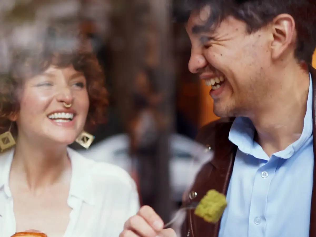 A couple laughing over breakfast in a café