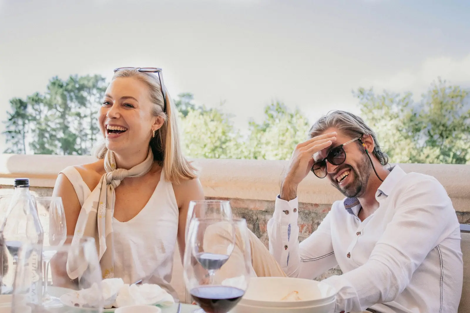 Un couple qui rit ensemble pendant un déjeuner à une table en terrasse