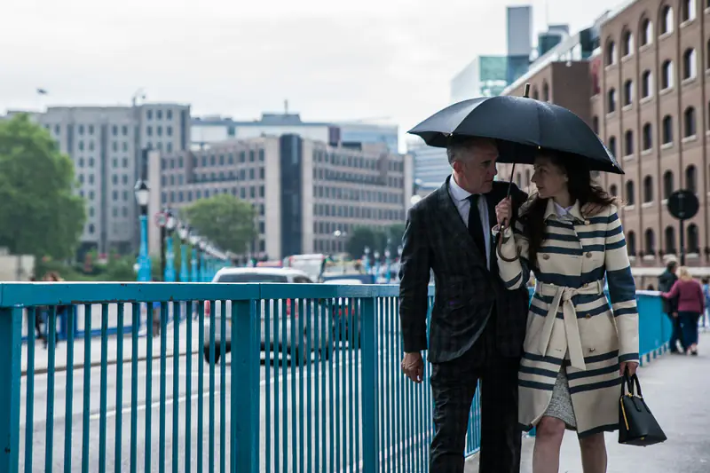 A couple sharing an umbrella on a London bridge