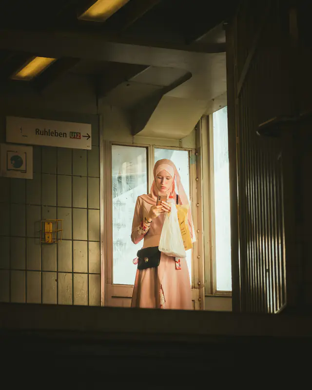 Une femme qui regarde son téléphone à l’entrée d’une gare